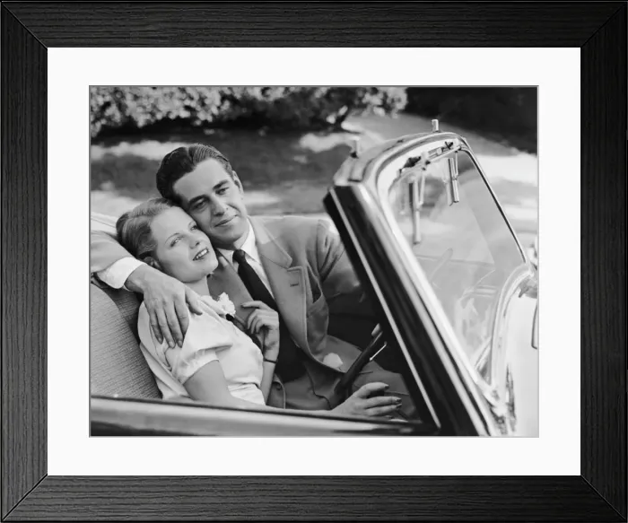 Framed Print : Loving couple in sports convertible