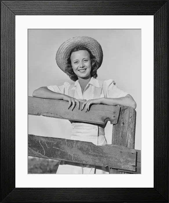 Framed Print : Woman smiling while leaning on a wooden fence Framed Print : Woman smiling while leaning on a wooden fence