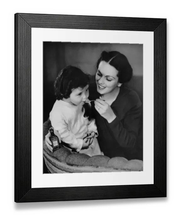 Framed Print : Mother giving spoon of medicine to child