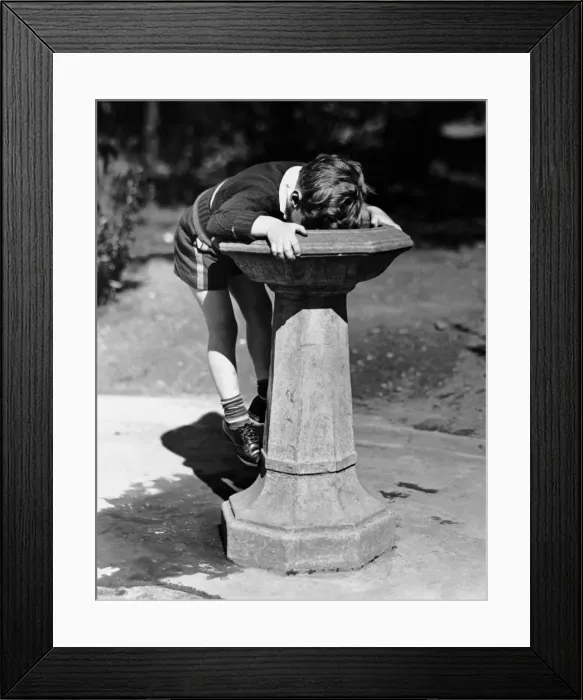 Framed Print : Young boy drinking from water fountain Framed Print : Young boy drinking from water fountain
