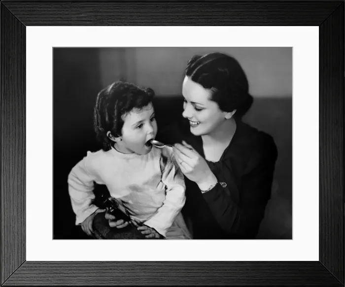 Framed Print : Mother giving medicine to daughter Framed Print : Mother giving medicine to daughter