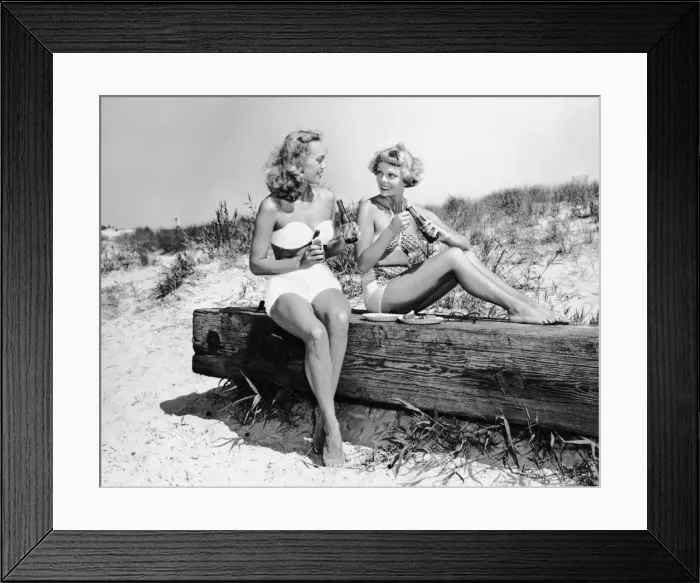 Framed Print : Two women drinking soda on beach