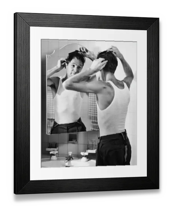 Framed Print : Man combing hair in bathroom