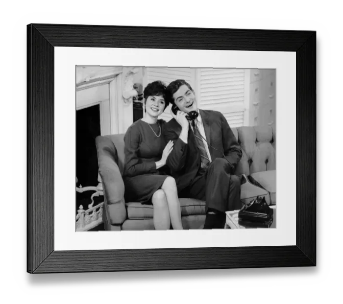 Framed Print : Couple sitting on couch w / telephone Framed Print : Couple sitting on couch w / telephone