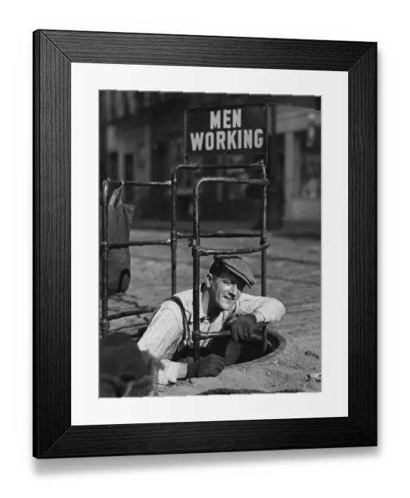 Framed Print : Worker climbing into manhole
