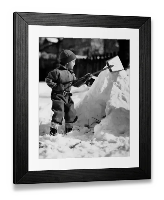 Framed Print : Boy playing with a shovel in the snow Framed Print : Boy playing with a shovel in the snow
