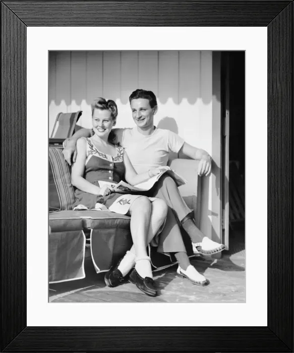 Framed Print : Portrait of young couple sitting outdoors Framed Print : Portrait of young couple sitting outdoors