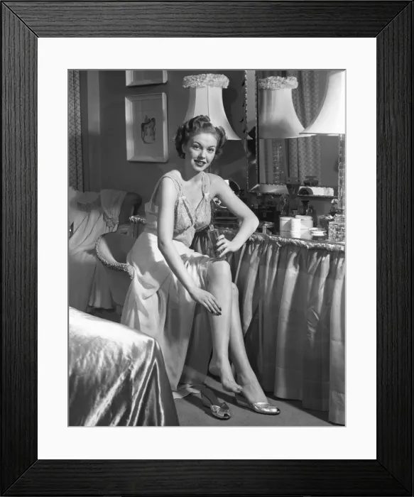 Framed Print : Woman in bedroom putting on lotion Framed Print : Woman in bedroom putting on lotion