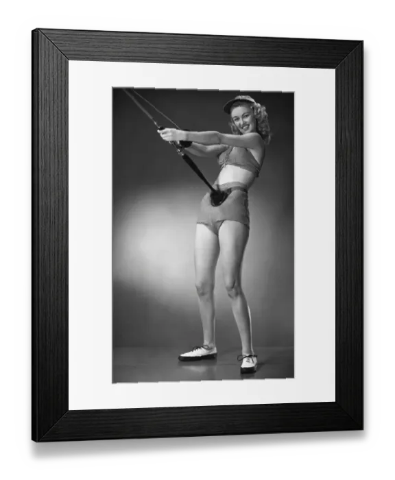 Framed Print : Woman in beachwear holding fishing rod Framed Print : Woman in beachwear holding fishing rod