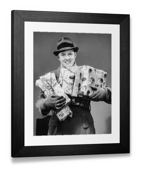 Framed Print : Man with coat, gloves and hat carrying Christmas gifts