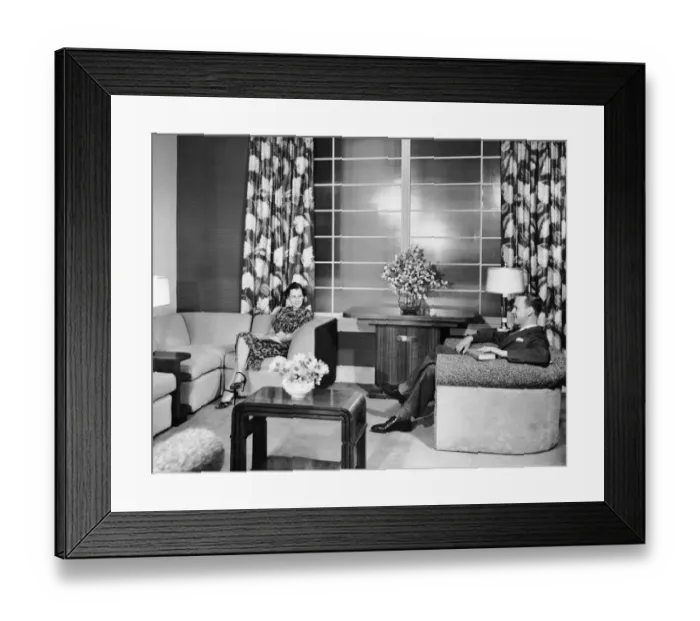 Framed Print : Couple sitting in living room reading Framed Print : Couple sitting in living room reading