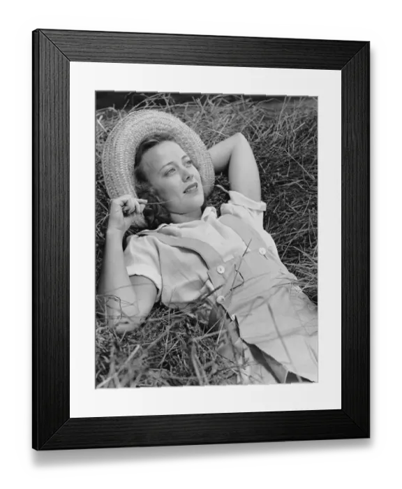 Framed Print : Young woman laying in hay thinking Framed Print : Young woman laying in hay thinking