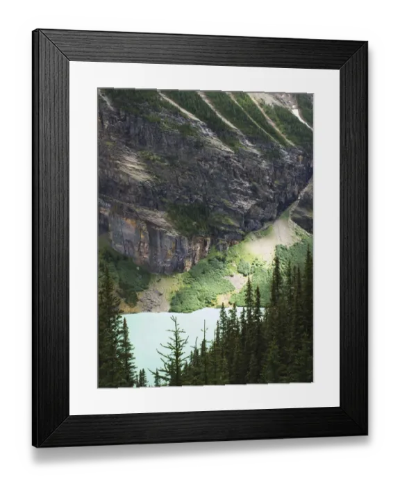 Framed Print : Rock face over green lake and pine trees, with interesting light Framed Print : Rock face over green lake and pine trees, with interesting light