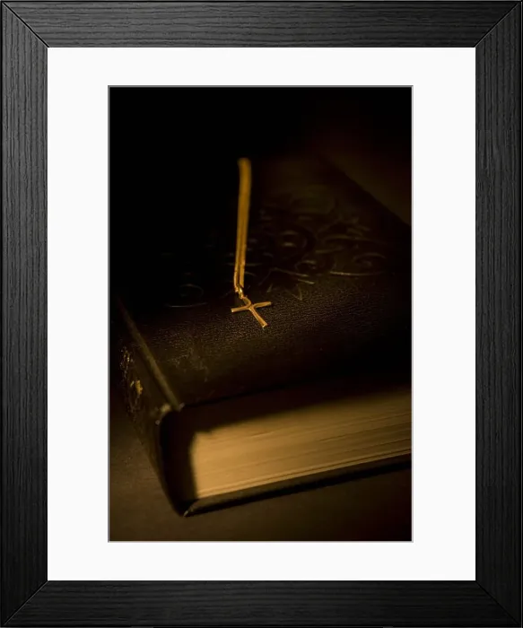 Framed Print : Gold cross pendant resting on a book Framed Print : Gold cross pendant resting on a book