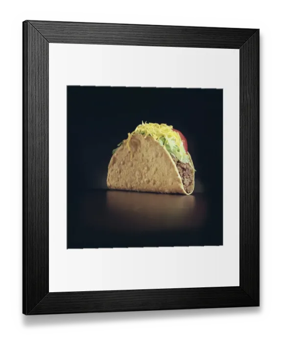 Framed Print : A Taco. View of a meat taco with lettuce and tomatos on a black background, January 1989 Framed Print : A Taco. View of a meat taco with lettuce and tomatos on a black background, January 1989