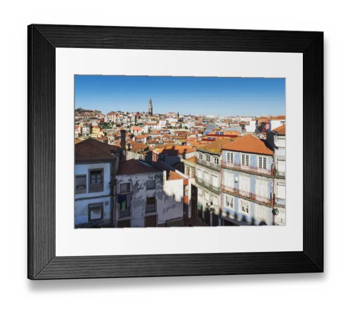 Framed Print : Rooftops of houses and a tower in the distance against a blue sky Framed Print : Rooftops of houses and a tower in the distance against a blue sky