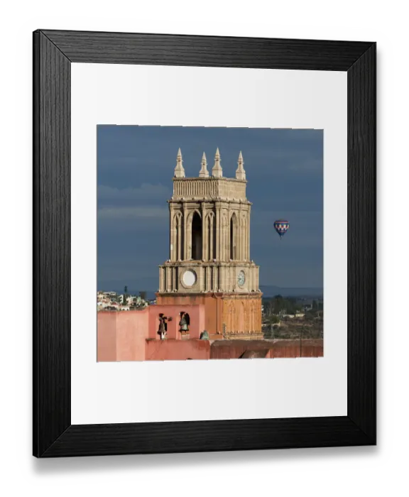Framed Print : Clock tower and bells of the parish church with a hot air balloon flight in the distance Framed Print : Clock tower and bells of the parish church with a hot air balloon flight in the distance