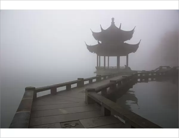A zig zag bridge and a Pavilion on the West Lake in foggy morning, Hangzhou