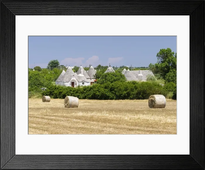 Framed Print : Stubble field, straw bales, Trulli houses, traditional round houses, at the back, near Locorotondo, Valle dItria, Apulia, Italy Framed Print : Stubble field, straw bales, Trulli houses, traditional round houses, at the back, near Locorotondo, Valle dItria, Apulia, Italy