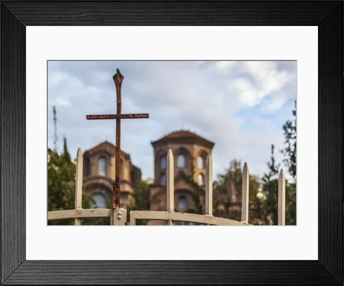 Framed Print : A rusty cross on a gate in front of a church Framed Print : A rusty cross on a gate in front of a church