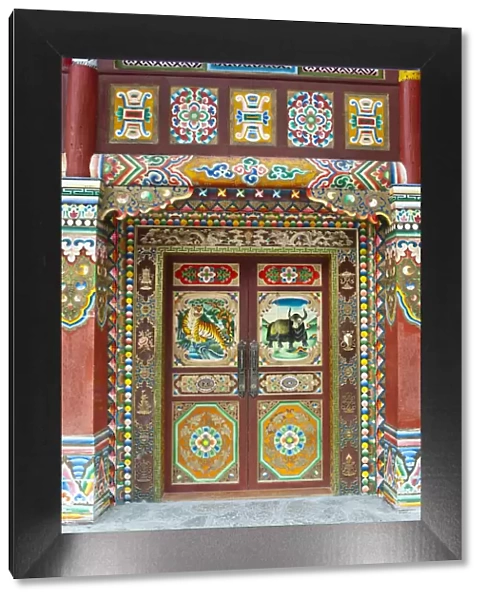 Colorful Tibetan designs on wall and door panels of temple, Jiuzhaigou National Scenic Area, Sichuan Province, China