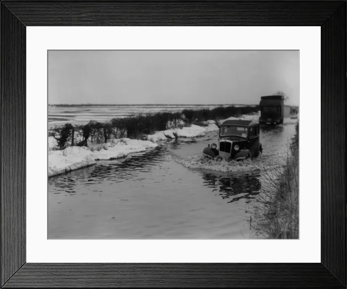 Framed Print : Thaw. 11th March 1947: Traffic plowing through water on a flooded road Framed Print : Thaw. 11th March 1947: Traffic plowing through water on a flooded road