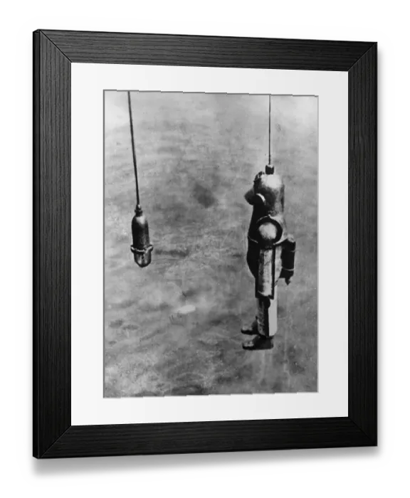 Framed Print : Diver. circa 1900: A diver goes down from the salvage ship Blakey to the Framed Print : Diver. circa 1900: A diver goes down from the salvage ship Blakey to the
