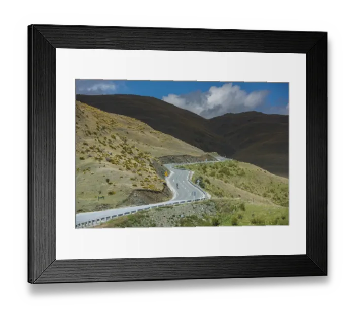 Framed Print : Cycler on a meandering road of Queenstown Framed Print : Cycler on a meandering road of Queenstown
