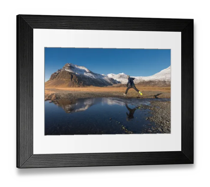 Framed Print : a man jumping across a water with snow mountain background Framed Print : a man jumping across a water with snow mountain background