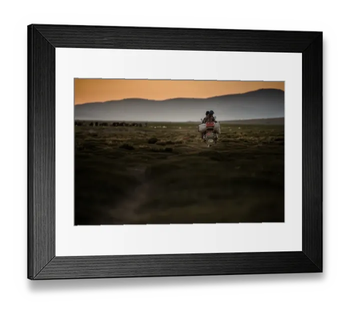 Framed Print : Motor bike riding on a field with sunset sky