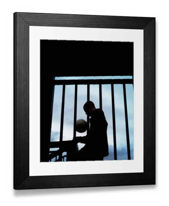 Framed Print : Young man with football by stairs and railing, silhouette Framed Print : Young man with football by stairs and railing, silhouette