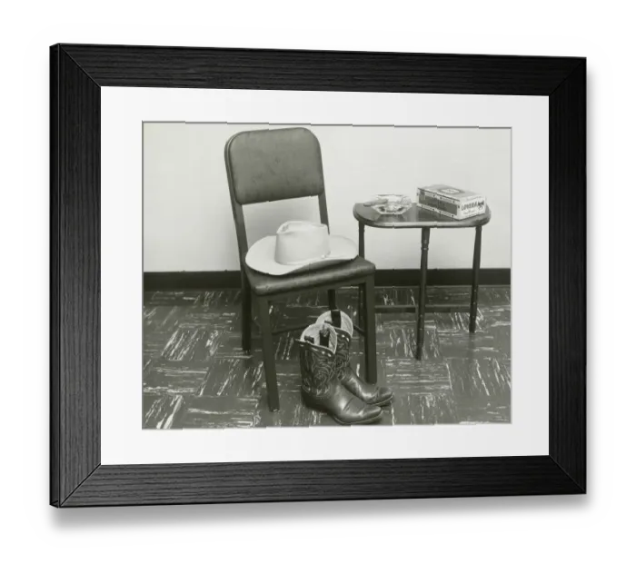 Framed Print : Cowboy hat and boots on chair beside table Framed Print : Cowboy hat and boots on chair beside table