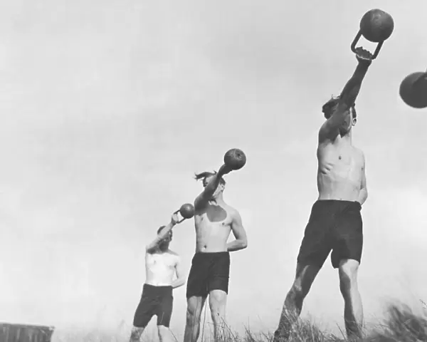 Group of young men exercising outdoors with weights (B&W)