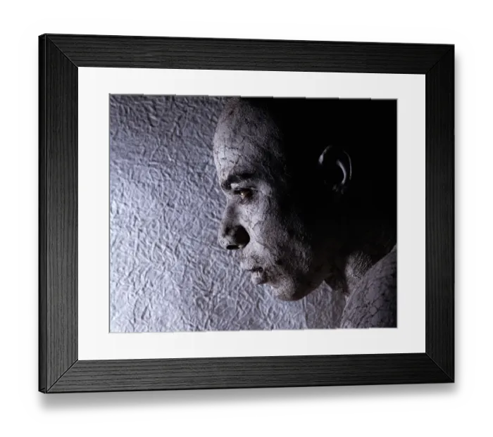 Framed Print : Man wearing face paint, near textured wall, close-up Framed Print : Man wearing face paint, near textured wall, close-up