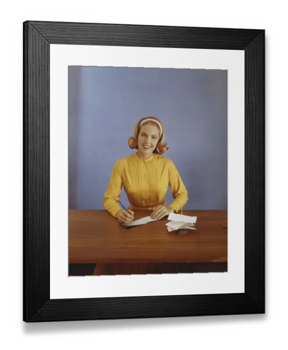 Framed Print : Young woman filling out bank slip, smiling, portrait Framed Print : Young woman filling out bank slip, smiling, portrait