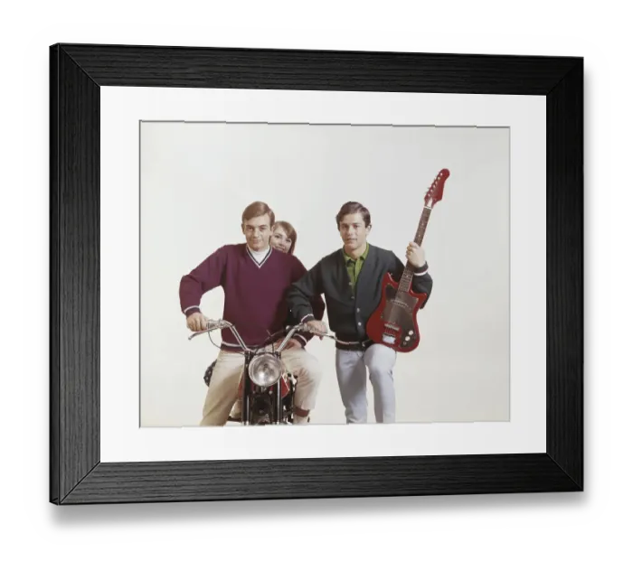 Framed Print : Friends with guitar and motorbike against white background, smiling, portrait