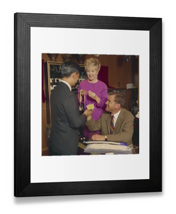 Framed Print : Man and woman buying pearl necklace in shop Framed Print : Man and woman buying pearl necklace in shop