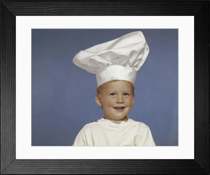 Framed Print : Boy wearing chefs hat, smiling, close-up Framed Print : Boy wearing chefs hat, smiling, close-up
