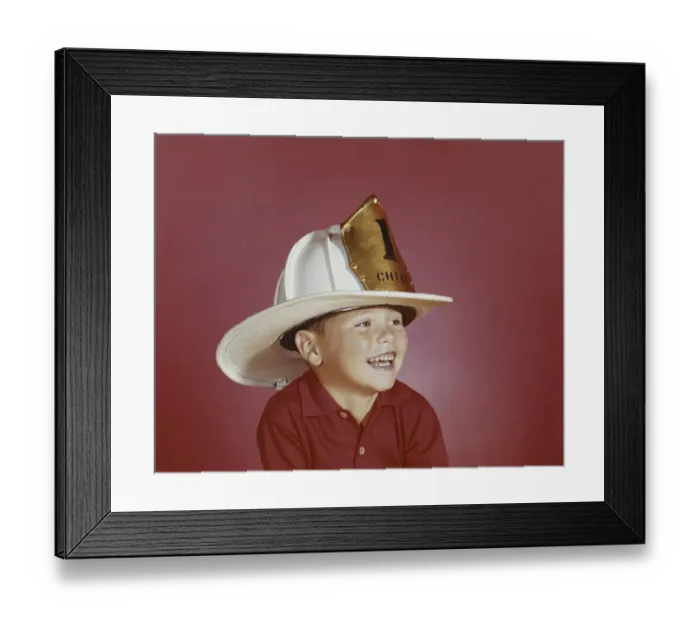 Framed Print : Boy wearing fireman hat, smiling, close-up Framed Print : Boy wearing fireman hat, smiling, close-up