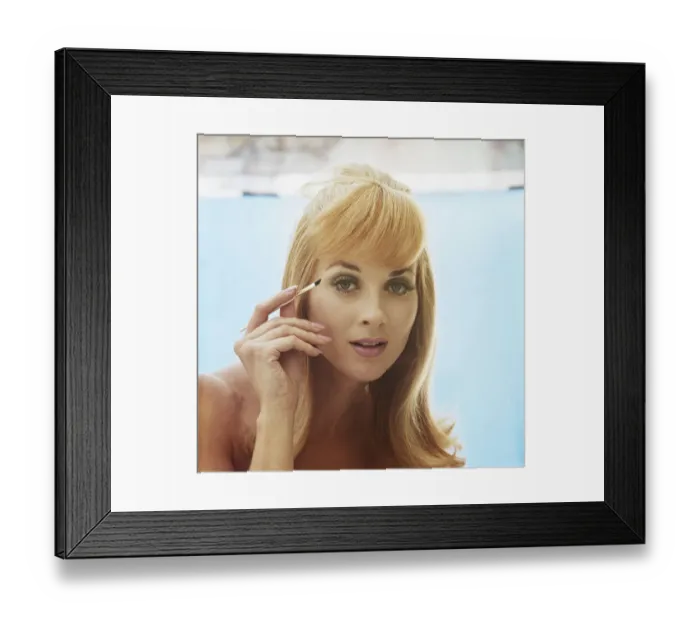 Framed Print : Young woman applying mascara, portrait, close-up