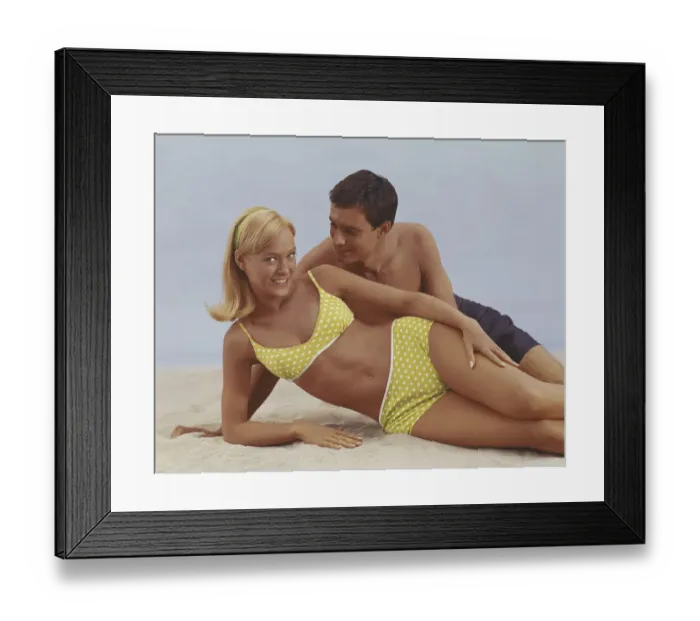 Framed Print : Young couple lying on sand, smiling Framed Print : Young couple lying on sand, smiling
