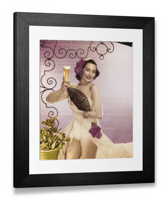 Framed Print : Young woman holding beer glass with folding fan, smiling, portrait Framed Print : Young woman holding beer glass with folding fan, smiling, portrait