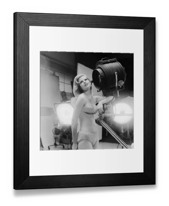 Framed Print : Young woman in bikini standing beside spotlight