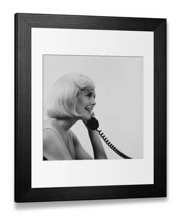 Framed Print : Young woman using telephone, smiling Framed Print : Young woman using telephone, smiling