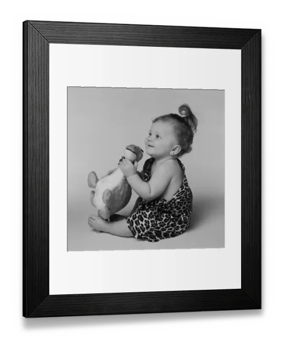 Framed Print : Baby girl playing with toy dinosaur, smiling Framed Print : Baby girl playing with toy dinosaur, smiling