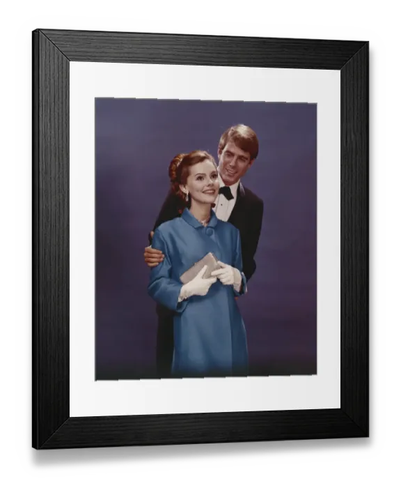 Framed Print : Couple in formal clothing standing against blue background, smiling Framed Print : Couple in formal clothing standing against blue background, smiling