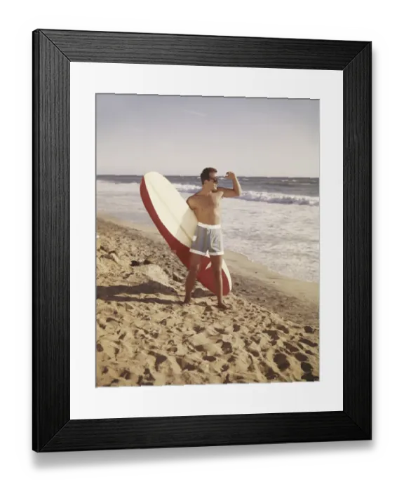 Framed Print : Surfer holding surfboard on beach Framed Print : Surfer holding surfboard on beach