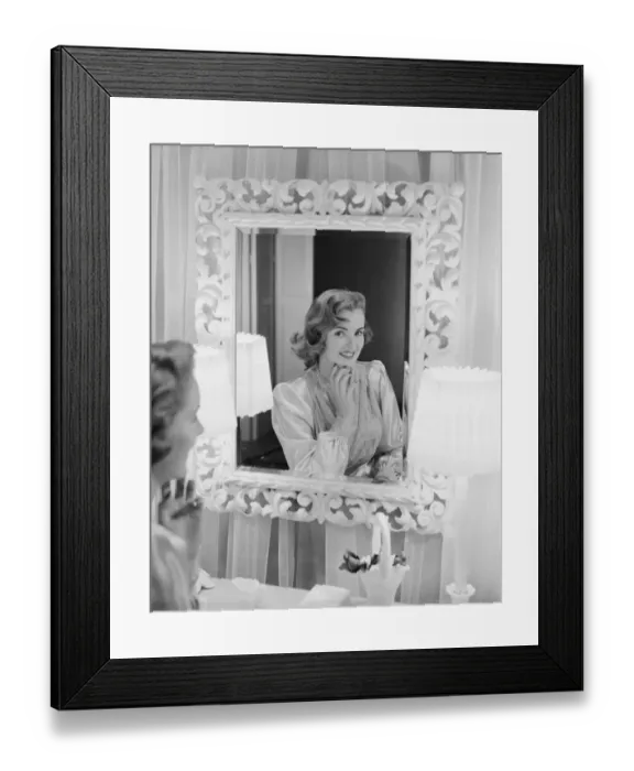 Framed Print : Young woman looking in mirror, smiling Framed Print : Young woman looking in mirror, smiling