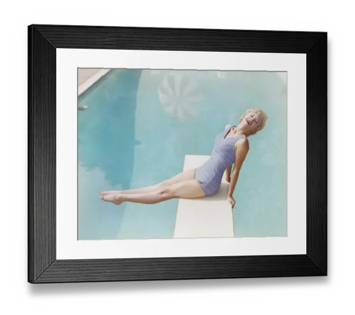 Framed Print : Young woman sitting on diving board, smiling, portrait Framed Print : Young woman sitting on diving board, smiling, portrait