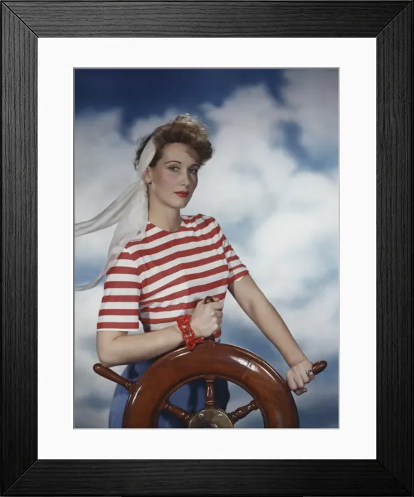 Framed Print : Young woman holding ship wheel, portrait